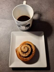 Una cambella con la cannella e una tazza di caffè
